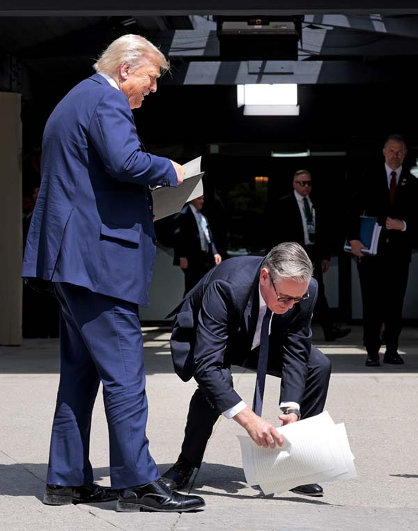 Starmer bends over to pick up papers for Trump